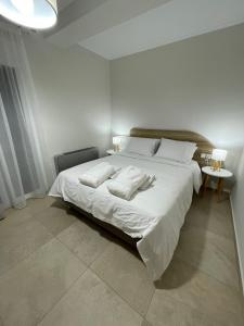 a bedroom with a large white bed with two pillows at TEGEA LUXURY SUITES Athena in Tripolis