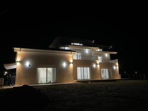 a large house with lights on it at night at TEGEA LUXURY SUITES Athena in Tripolis