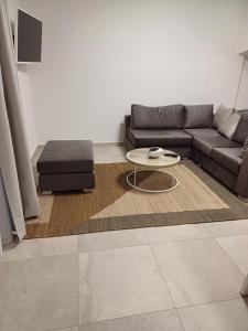 a living room with a couch and a coffee table at TEGEA LUXURY SUITES Athena in Tripoli