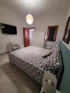 a bedroom with a large bed and a television at Makira in Terrasini