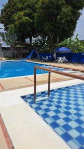 Hotel santa marta Melgar في ميلغار: حمام سباحة ذو أرضية ملونة زرقاء وبيضاء