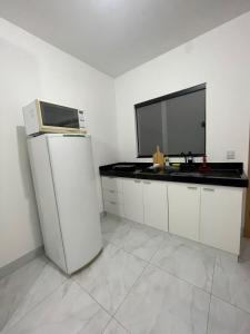 a kitchen with a refrigerator and a tv on a counter at Flat Completo Aparecida de Goiânia in Aparecida de Goiania