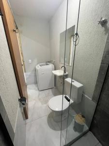 a bathroom with a toilet and a glass shower at Flat Completo Aparecida de Goiânia in Aparecida de Goiania
