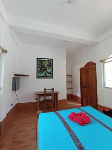 a bedroom with a blue bed and a table at Reserva Natural Cañón Seacacar in Izabal