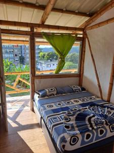 a bed sitting in a room with a window at Hotel santa marta Melgar in Melgar