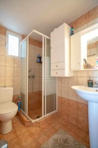 y baño con ducha, aseo y lavamanos. en Relax view, en Kalívia Thorikoú