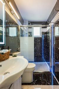 a bathroom with a sink and a toilet and a shower at Arcade central retro apartment in Rethymno Town