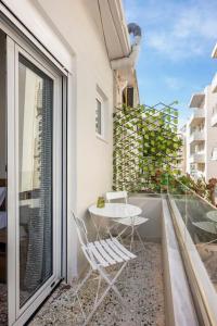 a balcony with two chairs and a table on a balcony at Arcade central retro apartment in Rethymno
