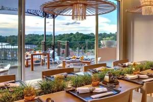 a restaurant with tables and chairs and a large window at Cozy 2-bedroom villa on river mouth in Terre Rouge