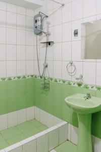 - une salle de bains verte et blanche pourvue d'un lavabo et d'une douche dans l'établissement MODERNO DEPARTAMENTO CON 4 HABITACIONES, à Huancayo