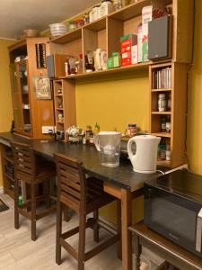 eine Küche mit einem Tisch mit Stühlen und einer Mikrowelle in der Unterkunft Jacks Court B1 in Stalybridge