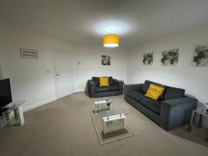 a living room with two couches and a table at Fleetwood - 3 bedroom apartment, fab 4 contractors in Gateshead
