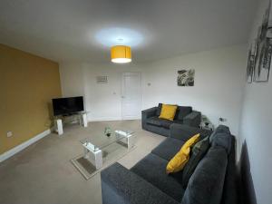 ein Wohnzimmer mit einem Sofa und einem TV in der Unterkunft Fleetwood - 3 bedroom apartment, fab 4 contractors in Gateshead