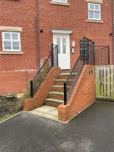 a set of stairs leading to a brick building at Fleetwood - 3 bedroom apartment, fab 4 contractors in Gateshead