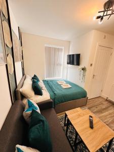 バーミンガムにあるR2 - Newly renovated Luxury Private En-Suite Room in Harborne Park Road - Birminghamのベッド1台とソファが備わる小さな客室です。