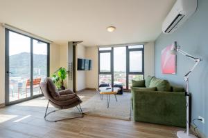 a living room with a green couch and chairs at Casco View By Wynwood House in Panama City