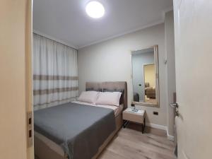 een kleine slaapkamer met een bed en een spiegel bij Center View Luxury Apartment in Tirana