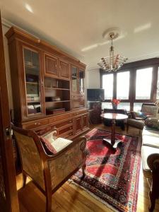 a living room with a chair and a table in a room at Elegante apartamento con vistas al puerto de Santander in Santander