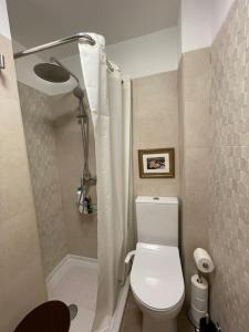 mała łazienka z toaletą i prysznicem w obiekcie Elegante apartamento con vistas al puerto de Santander w mieście Santander