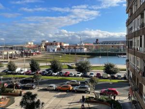 een parkeerplaats met auto's geparkeerd op een parkeerplaats bij Elegante apartamento con vistas al puerto de Santander in Santander
