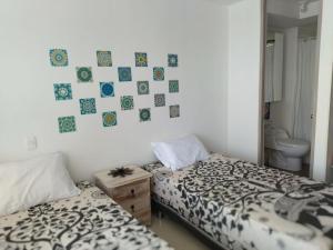 a bedroom with two beds and a picture on the wall at la aldea relax in Ricaurte