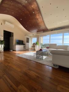 a living room with a wooden ceiling and a couch at Villa Dinka VIP apartmani in Opatija