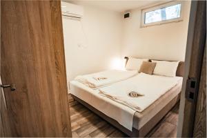 a bedroom with a bed with white sheets and a window at Siocamping in Siófok