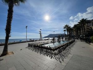 ein Strand mit einem Leuchtturm und einer Palme in der Unterkunft Imperial Park - Bungalow 3503 in Calpe