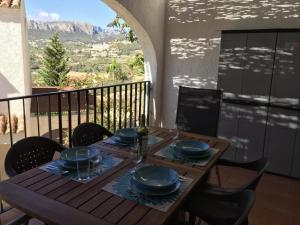 einen Holztisch mit blauen Gerichten auf dem Balkon in der Unterkunft Imperial Park - Bungalow 3503 in Calpe