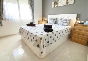 ein Schlafzimmer mit einem großen weißen Bett mit Polka-Punkten in der Unterkunft Imperial Park - Bungalow 3503 in Calpe