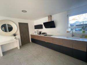 a large kitchen with a sink and a window at Villa plein pied in Lingolsheim