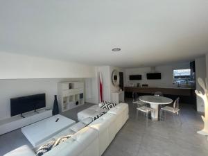 ein Wohnzimmer mit einem weißen Sofa und einem Tisch in der Unterkunft Villa plein pied in Lingolsheim