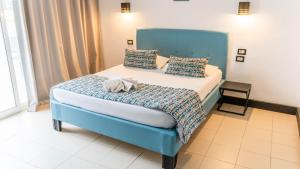 1 dormitorio con 1 cama con cabecero azul y almohadas en HOTEL KAISER, en Sousse