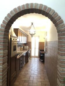 eine Küche mit einem Backsteinbogen in der Küche in der Unterkunft La Villetta del Gelso bianco in Aprilia