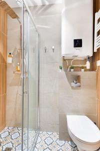 a bathroom with a toilet and a shower at Guestrust- Arc de Triomphe Corail in Paris