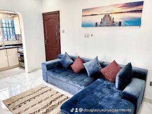 een blauwe bank in een woonkamer bij Commander Place Accra-Urban Budget Living 1,2-Beds in Oyarifa, Wifi, 5star service, 35mins to airport, by DLA in Oyarifa