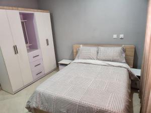 een slaapkamer met een bed en een dressoir bij Commander Place Accra-Urban Budget Living 1,2-Beds in Oyarifa, Wifi, 5star service, 35mins to airport, by DLA in Oyarifa