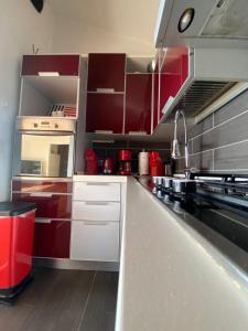 a kitchen with red and white cabinets and appliances at Villa Dinka VIP apartmani in Opatija