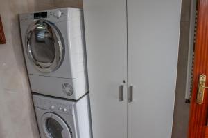 eine Waschmaschine und ein Trockner neben einem weißen Schrank in der Unterkunft Martins House in Vila Viçosa