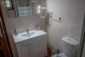 ein Badezimmer mit Waschbecken, Toilette und Spiegel in der Unterkunft Martins House in Vila Viçosa + 65 Fotos