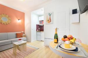 a living room with a couch and a table with fruit at Guestrust- Arc de Triomphe Corail in Paris