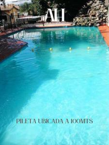 una piscina de agua azul en un complejo en American Hoteles en Villa Carlos Paz