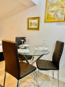 a dining room table with two chairs and a glass table at One Bed Studio Flat Free Car Park In London in London