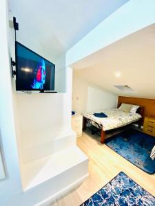 a bedroom with a bed and a tv on a wall at One Bed Studio Flat Free Car Park In London in London