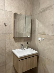 a bathroom with a sink and a mirror at TEGEA LUXURY SUITES Aphrodite in Tripolis