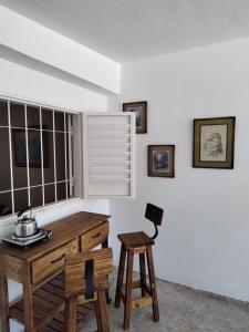 Habitación con mesa de madera y taburete. en La Mora Departamento en Mina Clavero