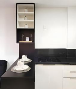 uma cozinha com armários brancos e um micro-ondas preto em Nosso Apê 915: Ar-condicionado | Piscina | Academia - NA1302 em Juiz de Fora