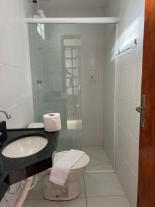 a bathroom with a sink and a toilet and a shower at Hospedaria Cumbuco - Kitnets Completas in Caucaia