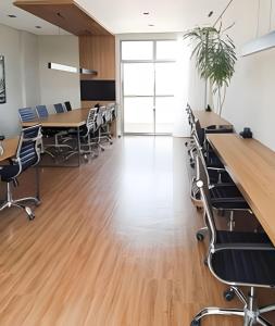 um escritório com secretárias e cadeiras e pisos em madeira em Nosso Apê 915: Ar-condicionado | Piscina | Academia - NA1302 em Juiz de Fora