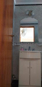 ein Bad mit einem Waschbecken und einem Spiegel in der Unterkunft Hospedaje BAHUINIAS II in Federación